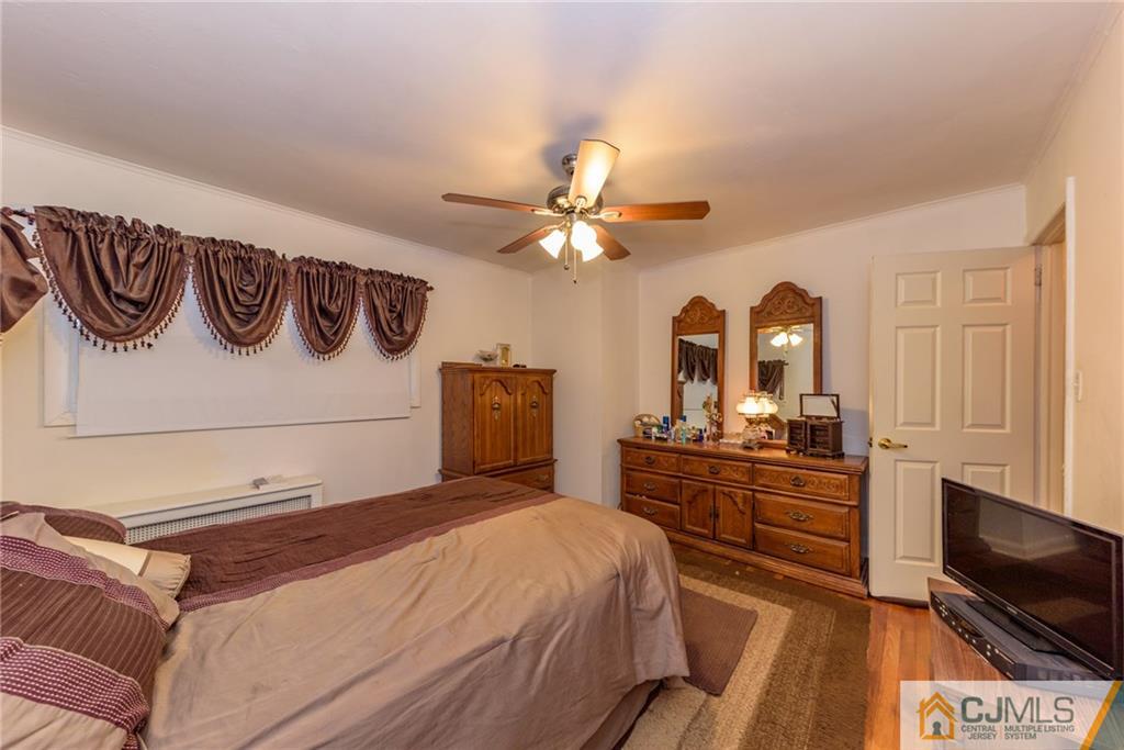 54 Phyllis Road West Orange, NJ 07052 - Photo 14 of 25 a bedroom with a bed and a flat screen tv