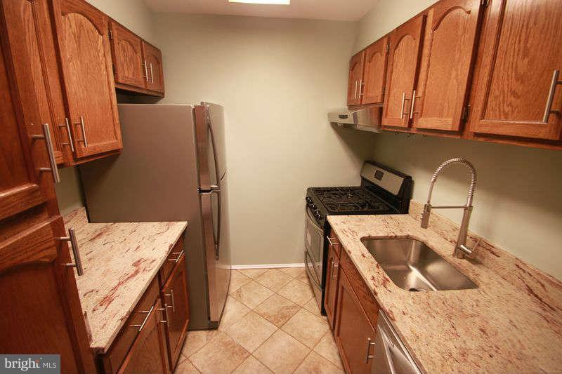 5807 Cove Landing Road, Unit 204 Burke, VA 22015 - Photo 2 of 17 a kitchen with stainless steel appliances granite countertop a sink stove and refrigerator