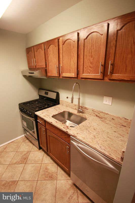 5807 Cove Landing Road, Unit 204 Burke, VA 22015 - Photo 3 of 17 a kitchen with stainless steel appliances granite countertop a sink a stove and cabinets