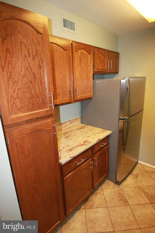 5807 Cove Landing Road, Unit 204 Burke, VA 22015 - Photo 4 of 17 a kitchen with stainless steel appliances granite countertop a refrigerator and a cabinets
