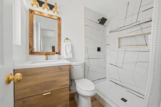 a bathroom with a sink a toilet and shower