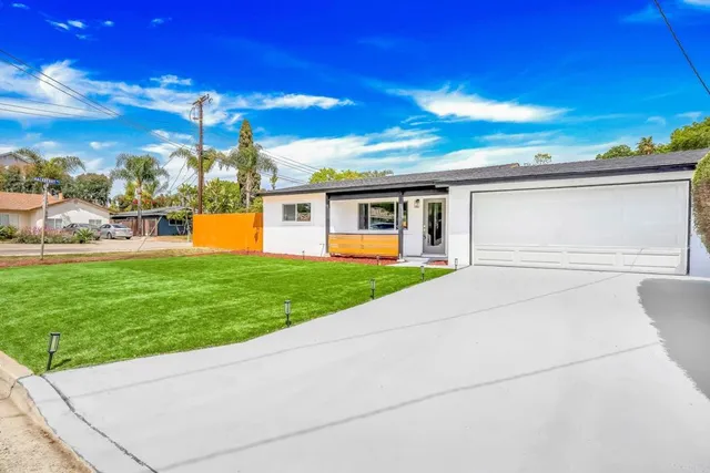 a view of a house with backyard and a tree