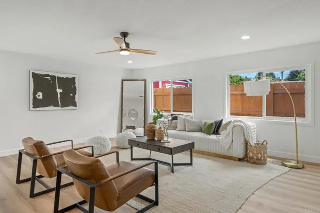 a living room with furniture and a ceiling fan