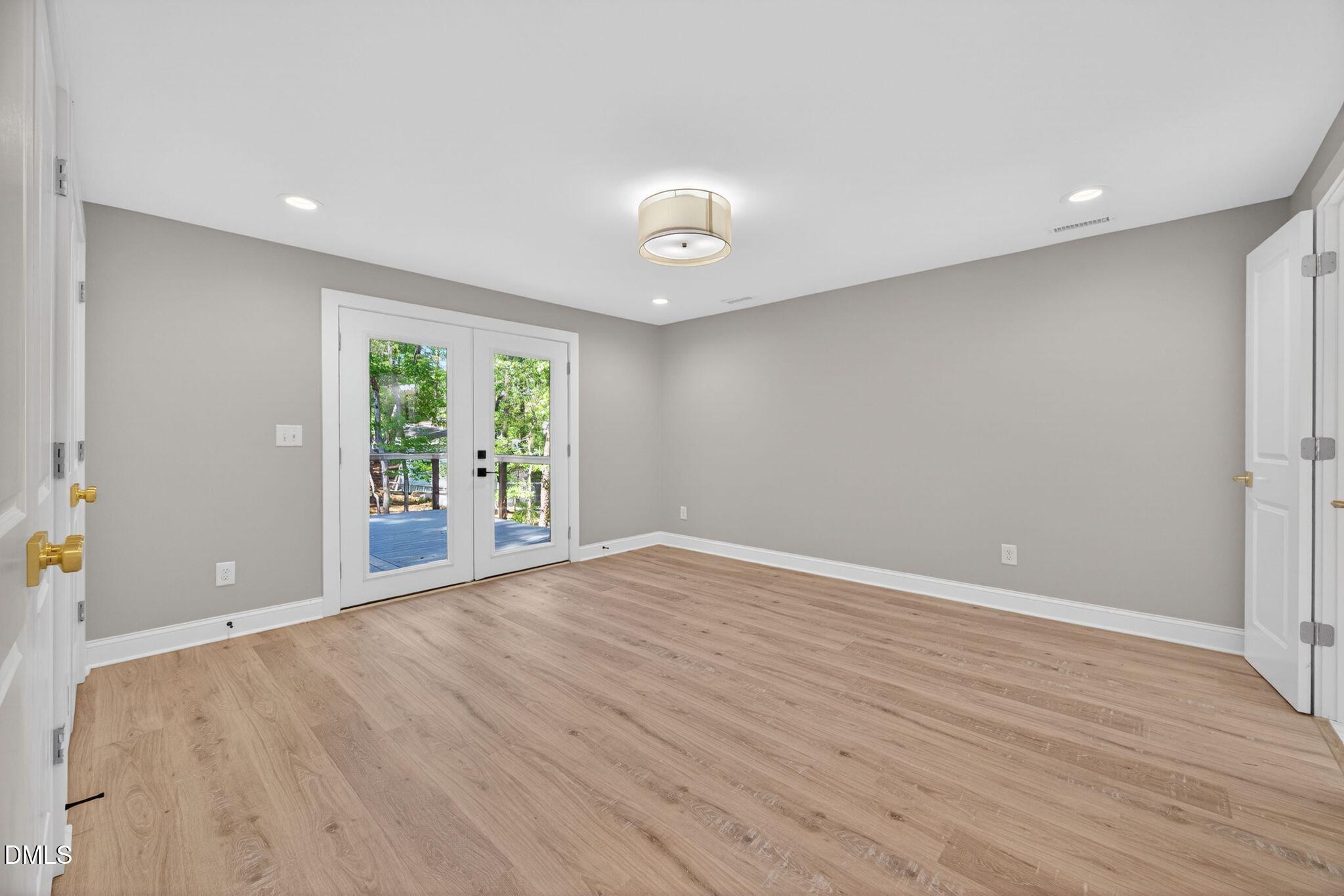 313 Crown Oaks Drive Raleigh, NC 27615 - Photo 53 of 60 a view of an empty room with wooden floor and a window