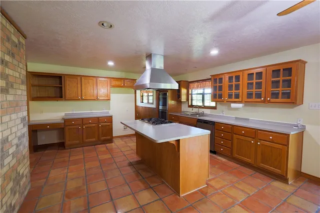 a open kitchen with granite countertop a stove top oven a sink and dishwasher