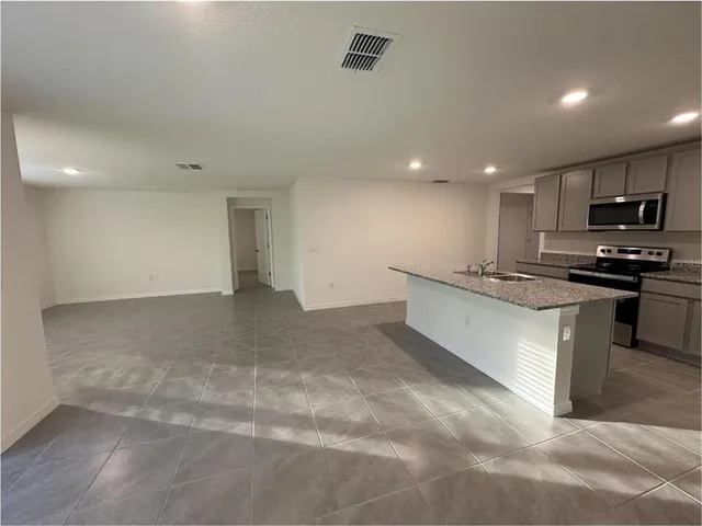 a large kitchen with stainless steel appliances lots of counter top space