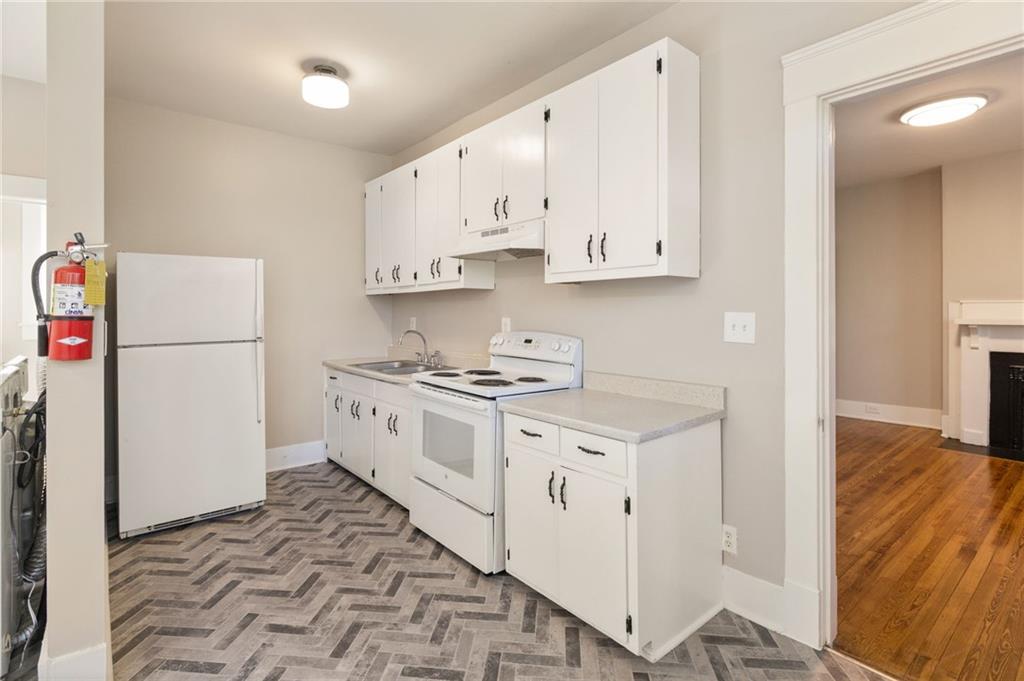 120 South Candler Street Decatur, GA 30030 - Photo 26 of 40 a kitchen with granite countertop a sink a stove a refrigerator and white cabinets