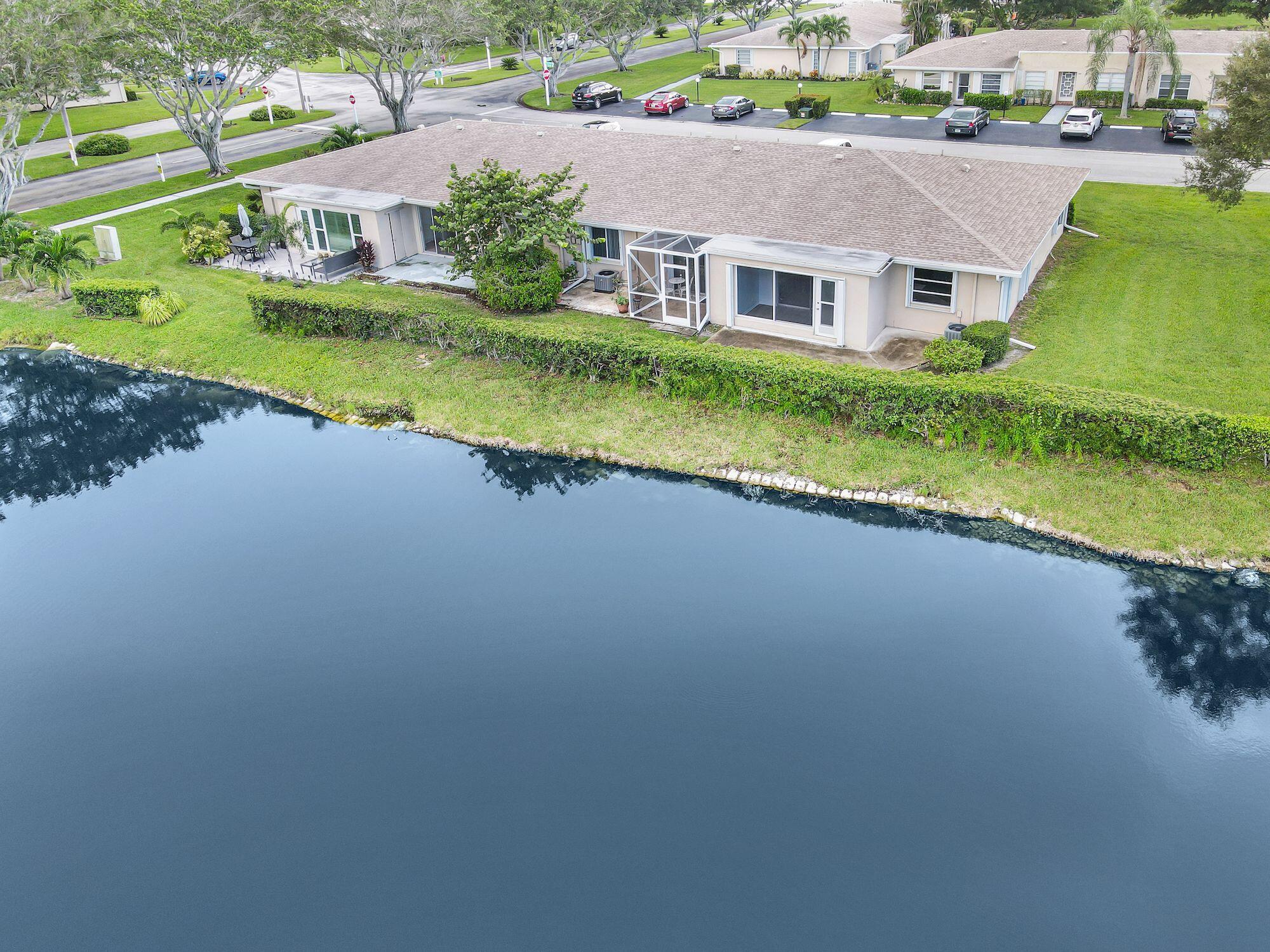 an aerial view of a house with a garden and lake view