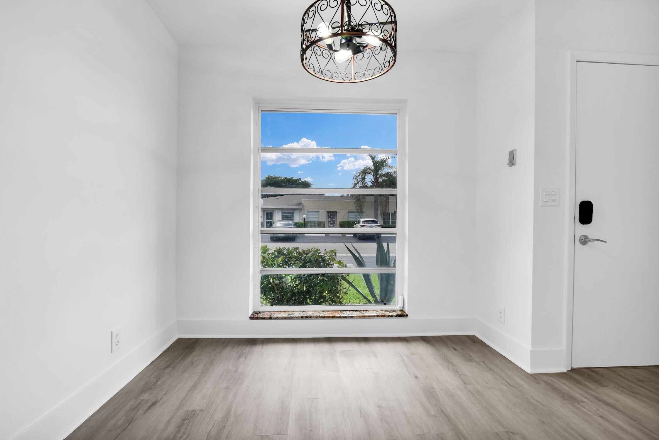 8807 Bella Vista Drive, Unit 280 Boca Raton, FL 33433 - Photo 14 of 44 a view of a hallway with wooden floor and a window