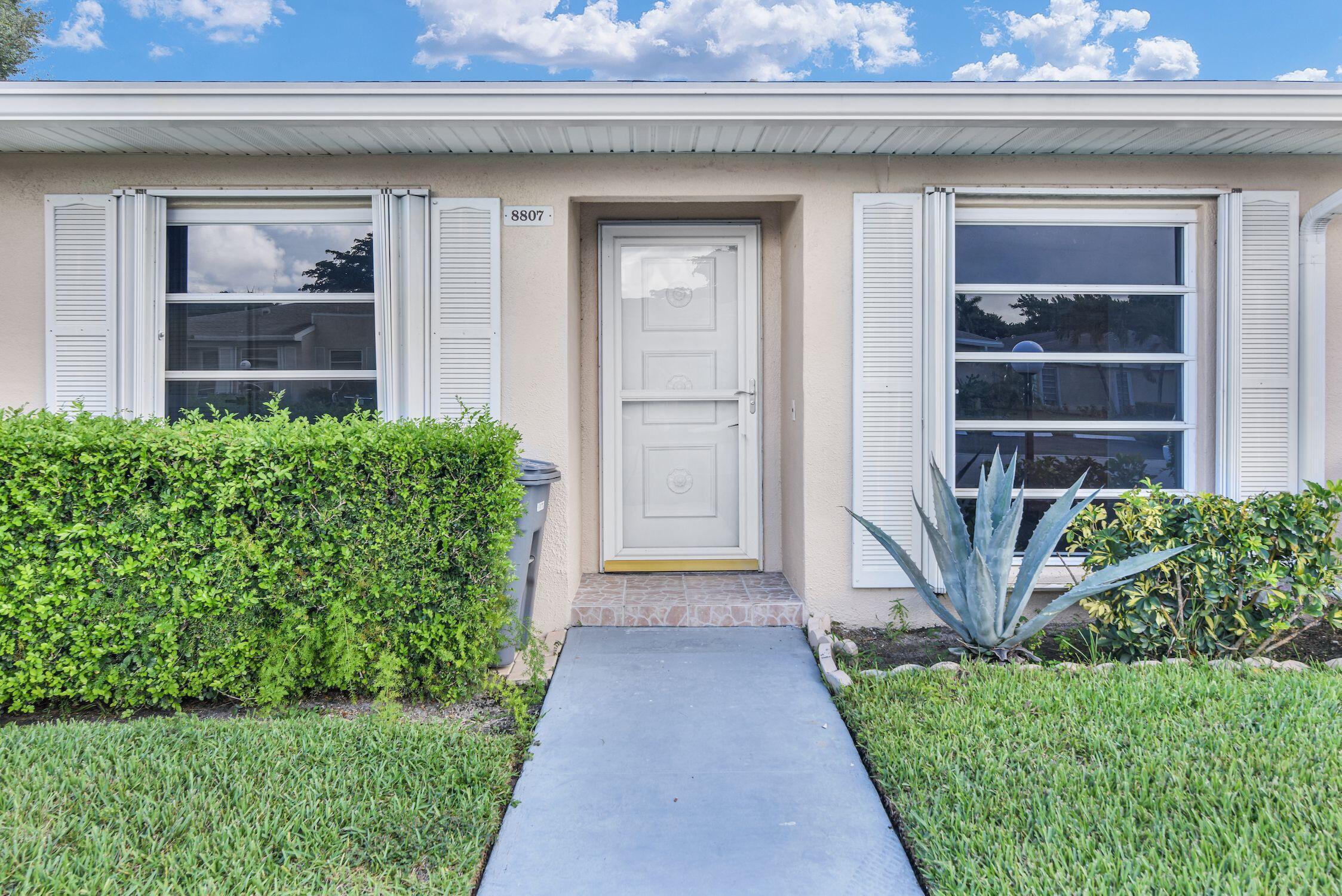 8807 Bella Vista Drive, Unit 280 Boca Raton, FL 33433 - Photo 2 of 44 a front view of a house with a yard