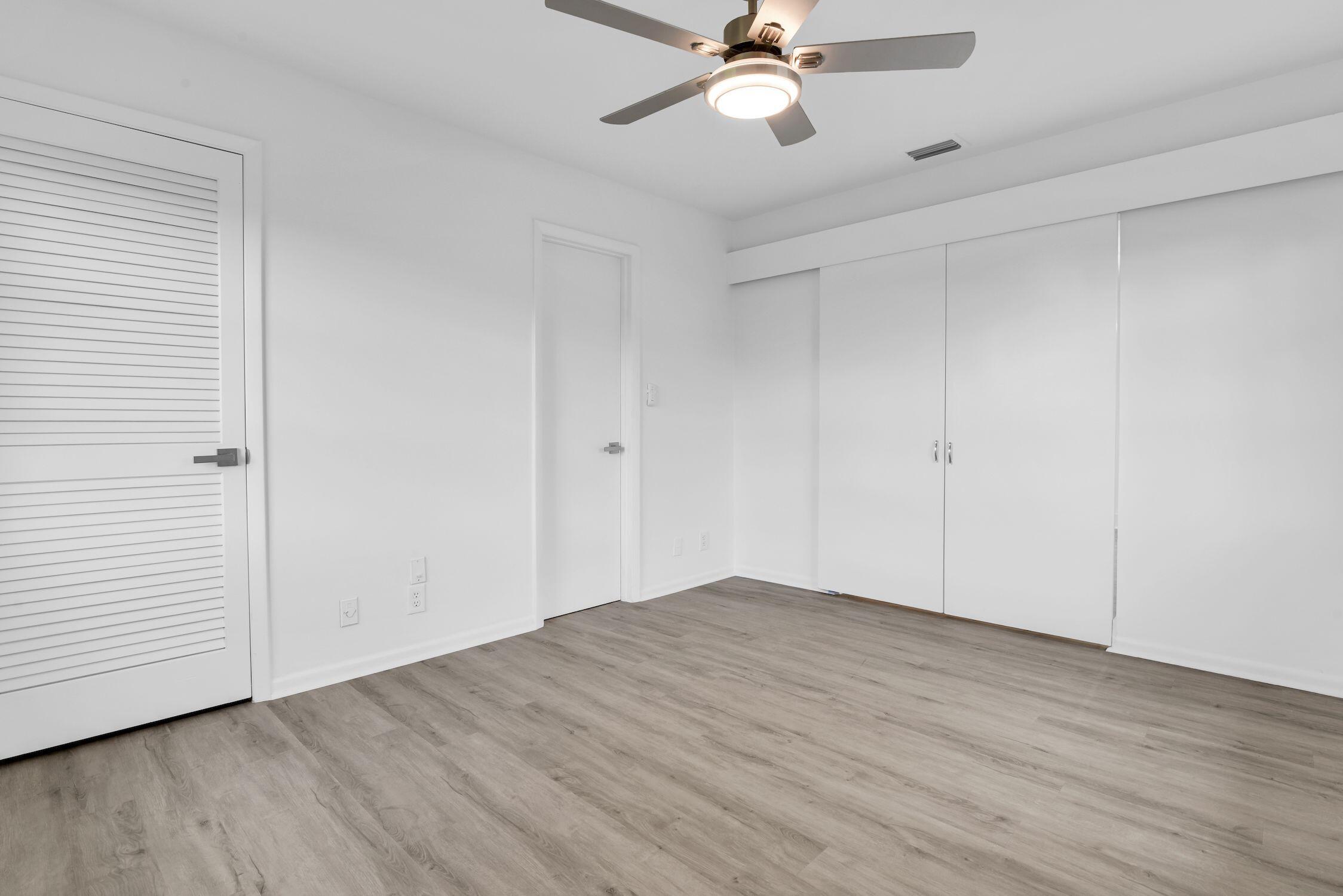 8807 Bella Vista Drive, Unit 280 Boca Raton, FL 33433 - Photo 25 of 44 an empty room with wooden floor closet and fan