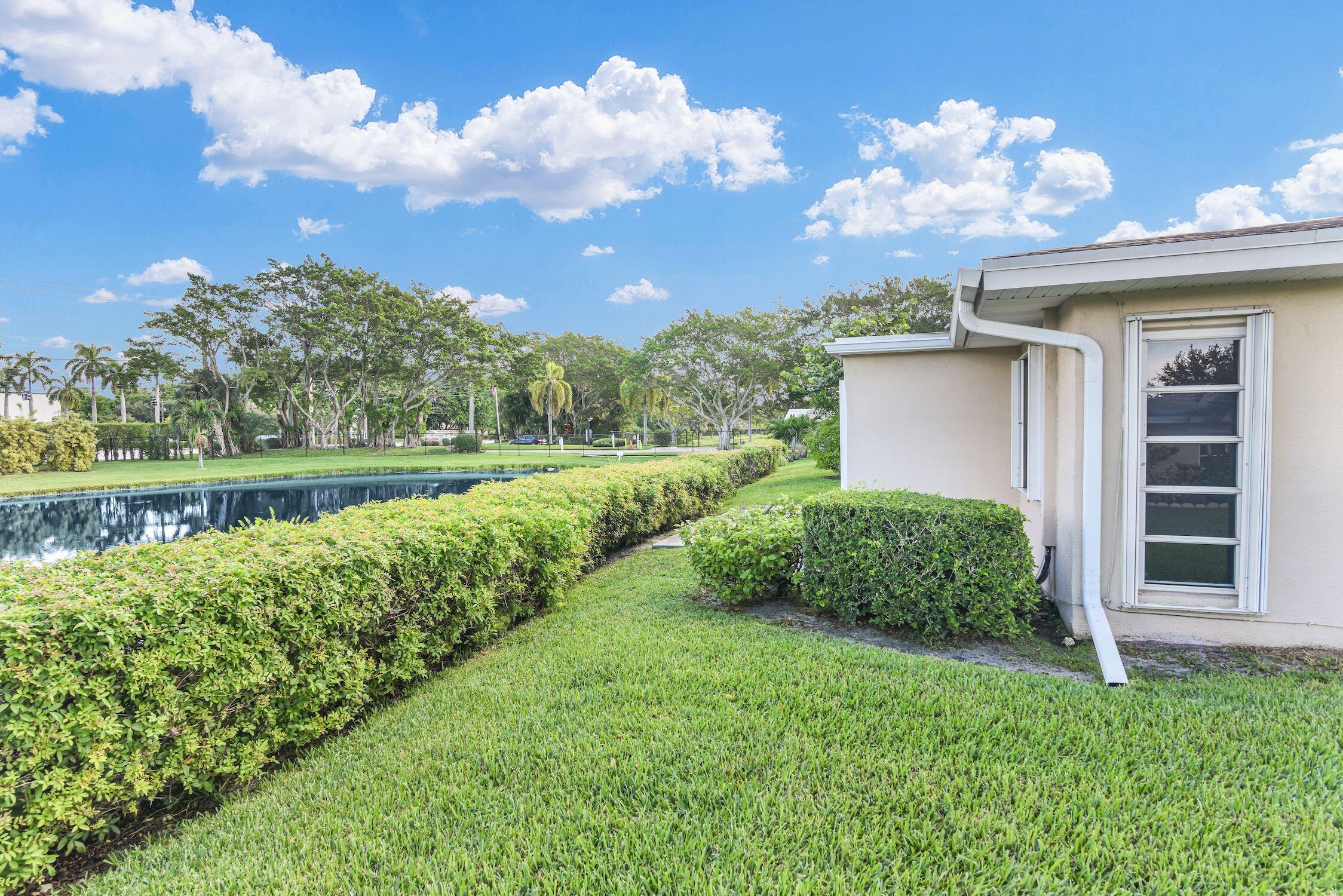 8807 Bella Vista Drive, Unit 280 Boca Raton, FL 33433 - Photo 31 of 44 a view of a house with a big yard and large trees