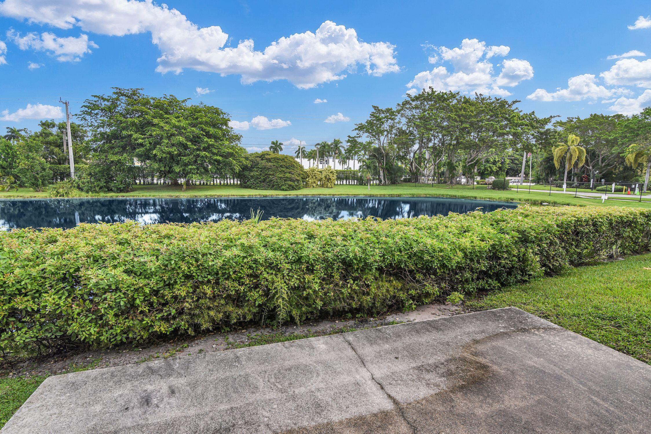8807 Bella Vista Drive, Unit 280 Boca Raton, FL 33433 - Photo 36 of 44 a view of a lake with a house in the background