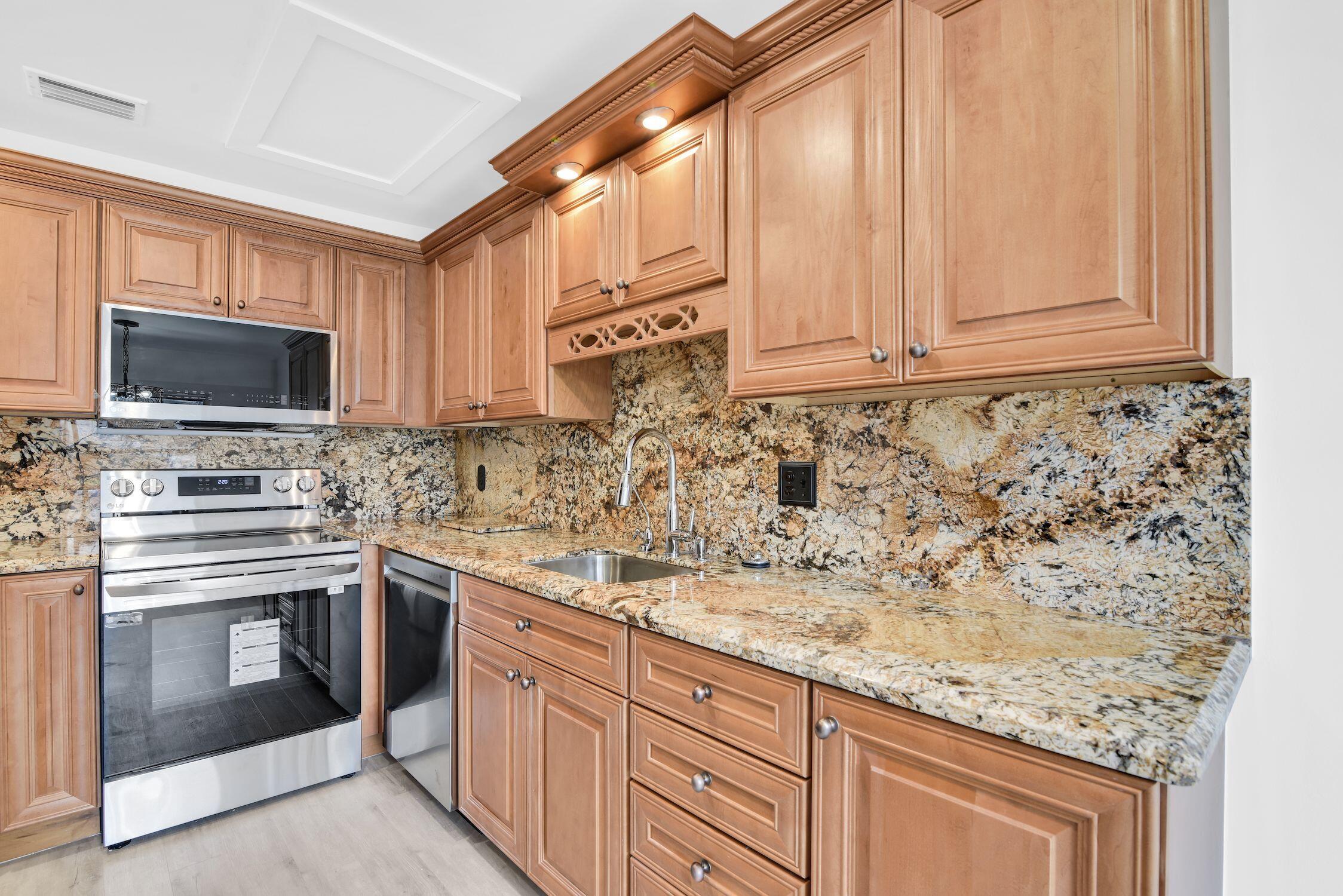 8807 Bella Vista Drive, Unit 280 Boca Raton, FL 33433 - Photo 5 of 44 a kitchen with stainless steel appliances granite countertop a sink and a stove