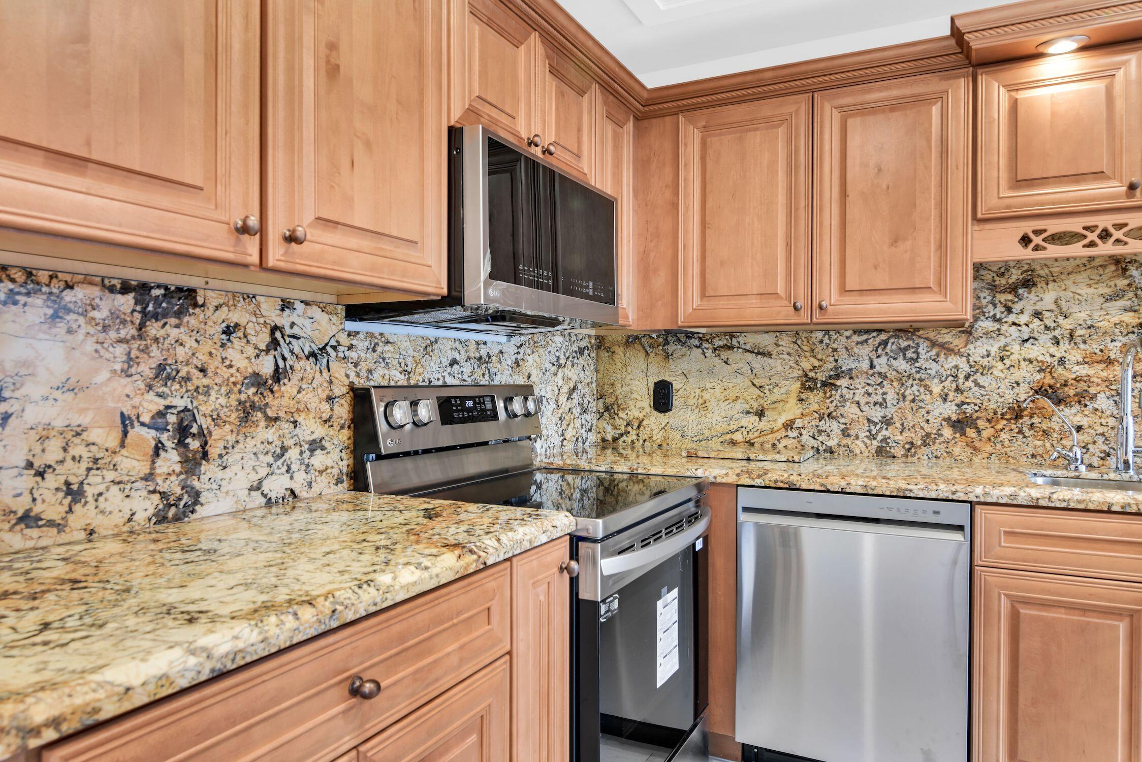 8807 Bella Vista Drive, Unit 280 Boca Raton, FL 33433 - Photo 7 of 44 a kitchen with stainless steel appliances granite countertop a sink stove and microwave