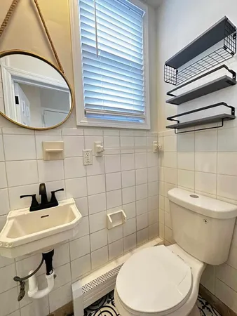 a bathroom with a sink a toilet and a mirror
