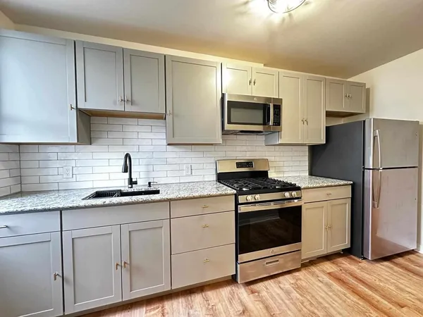 a kitchen with stainless steel appliances granite countertop a sink a stove a microwave and cabinets