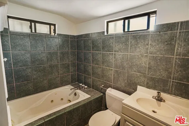 a bathroom with a sink mirror toilet and bathtub