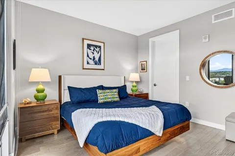 a bedroom with a bed and painting on the wall