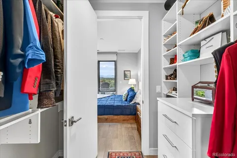 a view of walk in closet with clothes and shoes