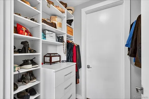 a view of walk in closet with clothes and shoes