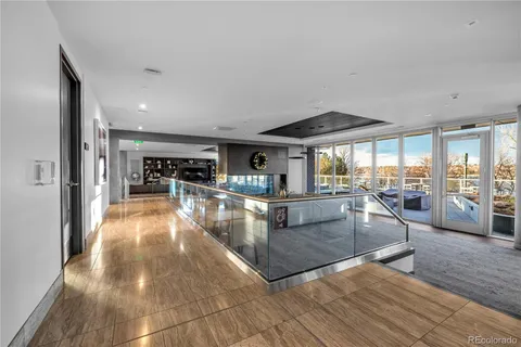 a dining hall with stainless steel appliances granite countertop a refrigerator a stove and white cabinets with wooden floor