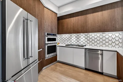 a kitchen with stainless steel appliances granite countertop a refrigerator and a stove
