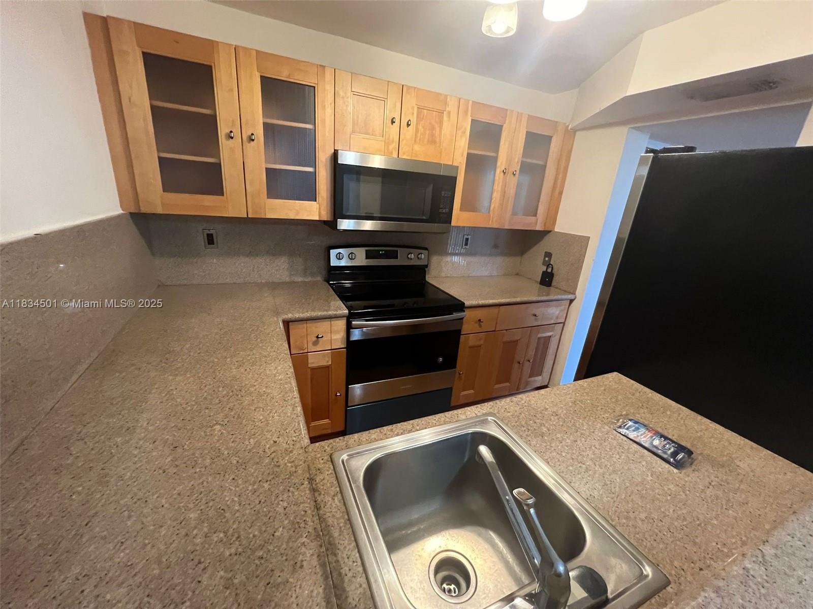 International Park Miami, FL 33175 - Photo 16 of 26 a kitchen with a refrigerator and a stove