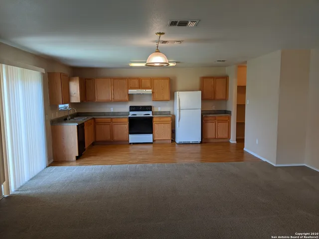 a view of kitchen with refrigerator stove microwave and stove with wooden floor