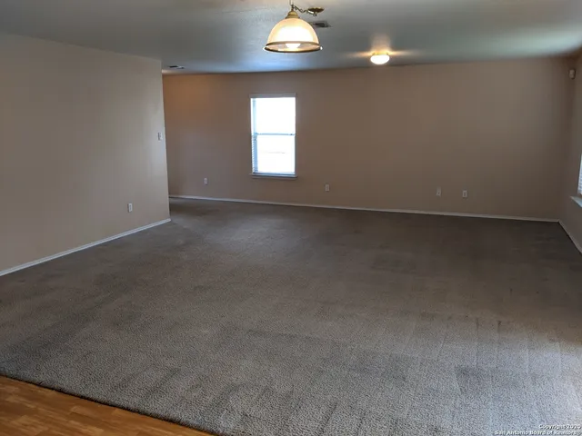 an empty room that has fireplace and windows