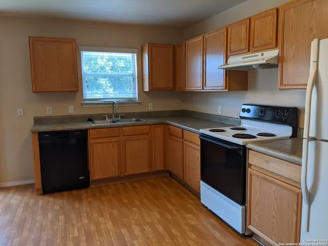a kitchen with granite countertop a sink cabinets and stainless steel appliances