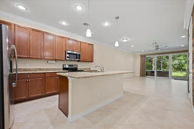 a large kitchen with stainless steel appliances granite countertop a stove a sink and a microwave