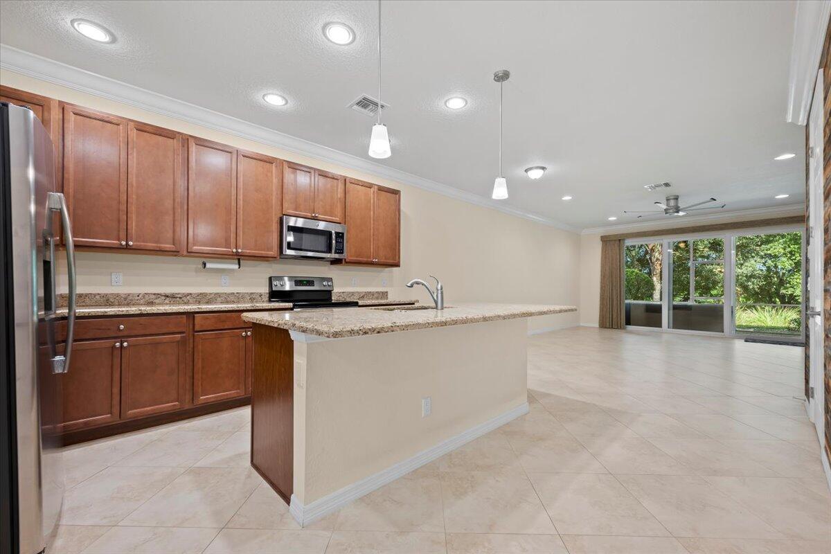 535 Southwest Glen Crest Way Stuart, FL 34997 - Photo 6 of 32 a large kitchen with stainless steel appliances granite countertop a stove a sink and a microwave