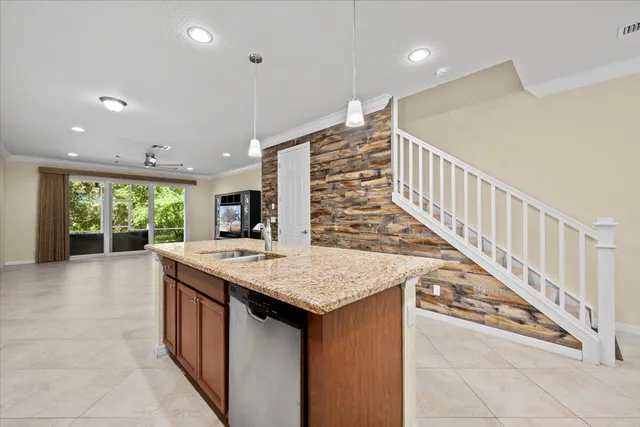 a dining hall with stainless steel appliances granite countertop a stove and a sink