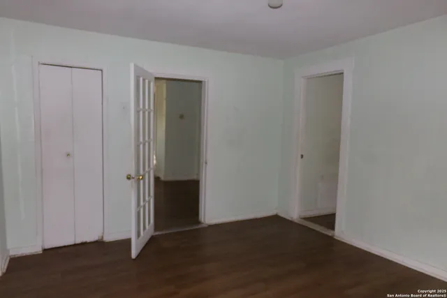 an empty room with wooden floor and a window