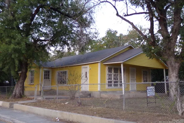 a view of a house with large windows and large tree