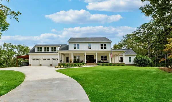 a front view of a house with a garden and trees