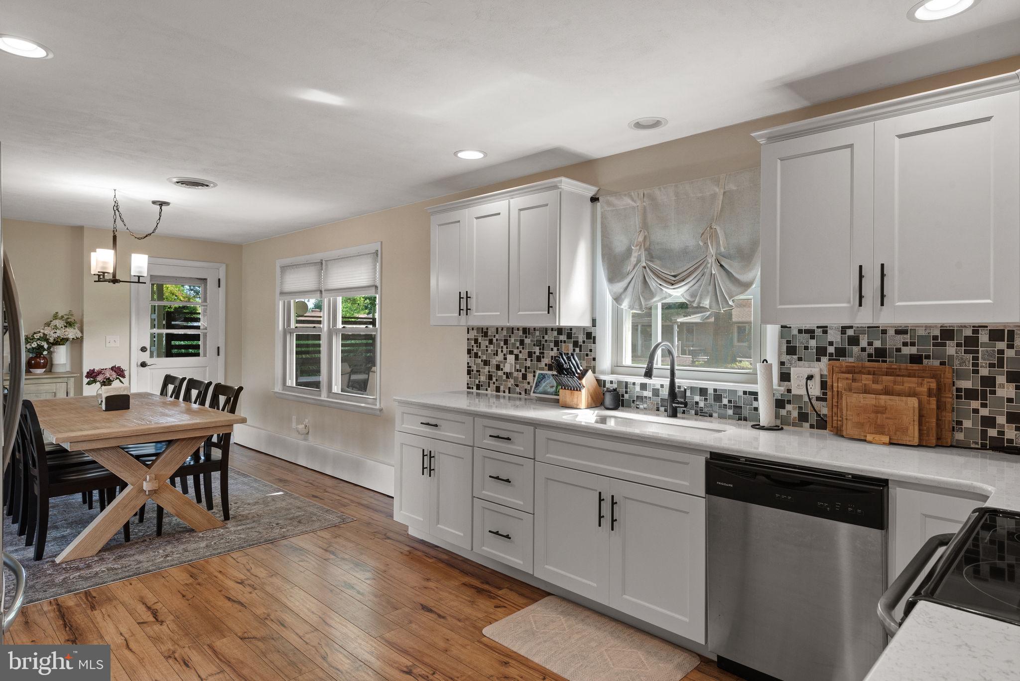 170 Hershey Drive Manheim, PA 17545 - Photo 16 of 33 a kitchen with stainless steel appliances kitchen island granite countertop a stove a sink dishwasher and white cabinets with wooden floor