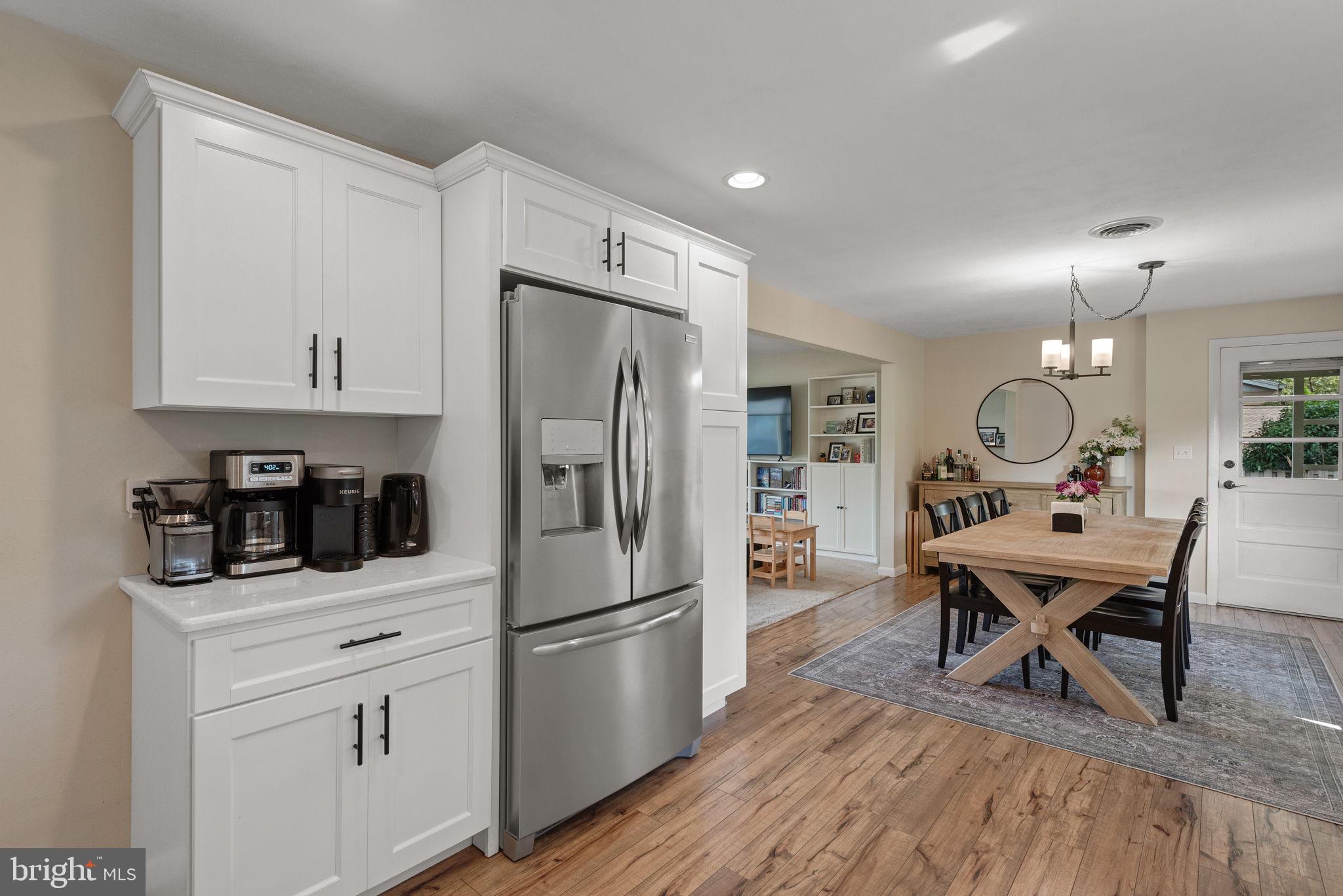 170 Hershey Drive Manheim, PA 17545 - Photo 17 of 33 a kitchen with stainless steel appliances a refrigerator a stove a dining table and chairs with wooden floor