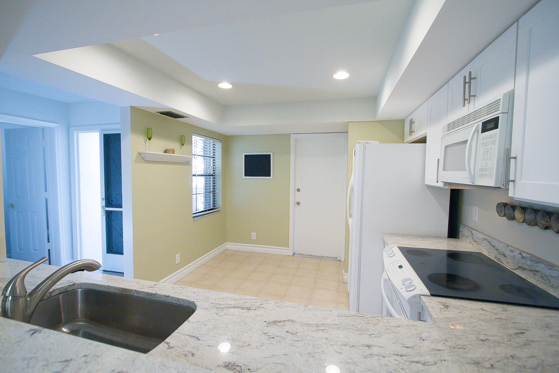 454 Ashwood Place Boca Raton, FL 33431 - Photo 8 of 30 a kitchen with granite countertop a sink and a refrigerator