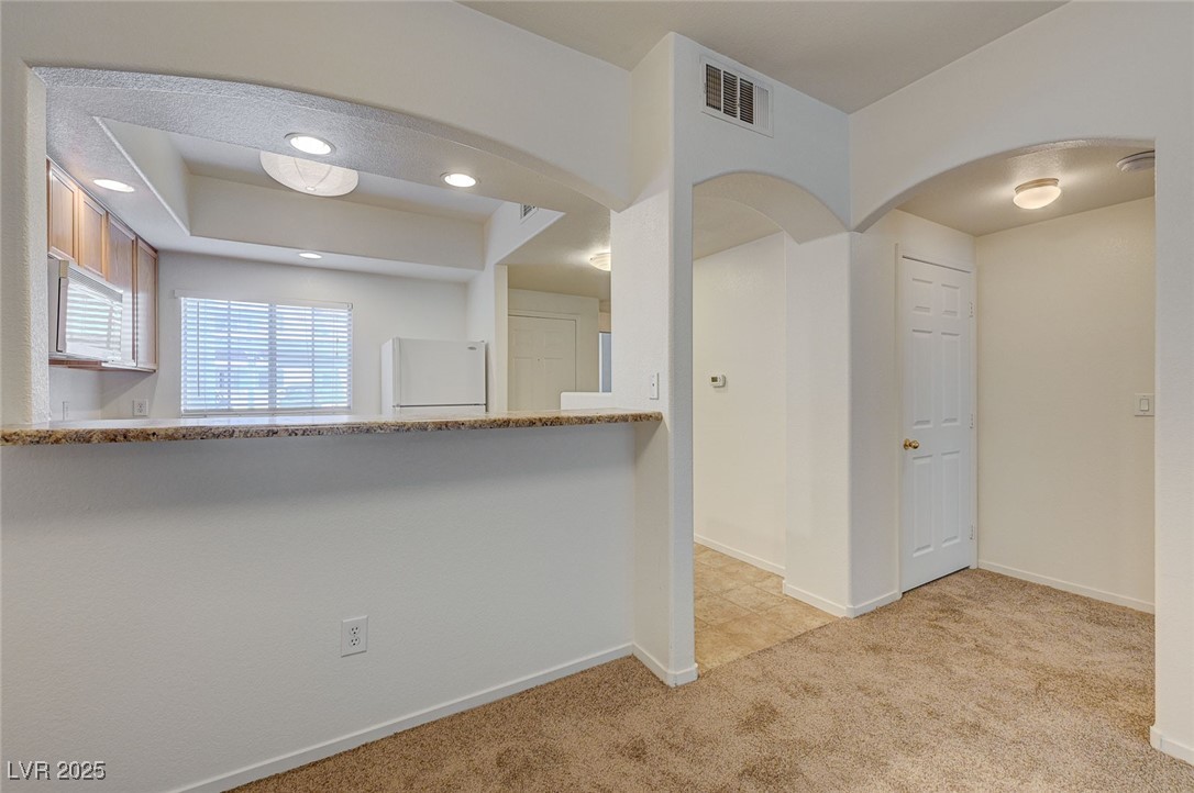 6160 Rumrill Street, Unit 232 Las Vegas, NV 89113 - Photo 11 of 26 Spare room featuring light carpet, arched walkways, and recessed lighting
