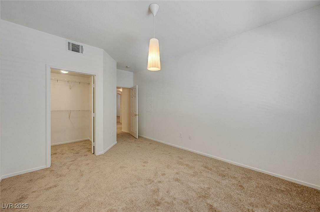 6160 Rumrill Street, Unit 232 Las Vegas, NV 89113 - Photo 20 of 26 Unfurnished bedroom with a walk in closet and carpet