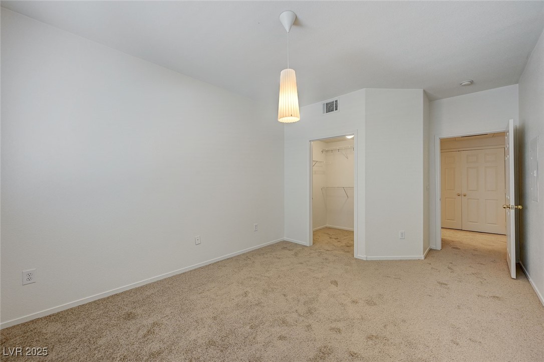 6160 Rumrill Street, Unit 232 Las Vegas, NV 89113 - Photo 21 of 26 Unfurnished bedroom featuring carpet floors and a walk in closet