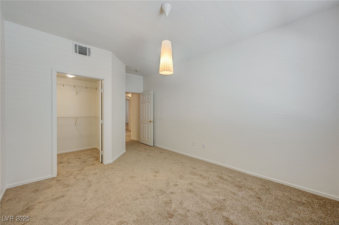 6160 Rumrill Street, Unit 232 Las Vegas, NV 89113 - Photo 22 of 26 Unfurnished bedroom with a walk in closet and carpet flooring
