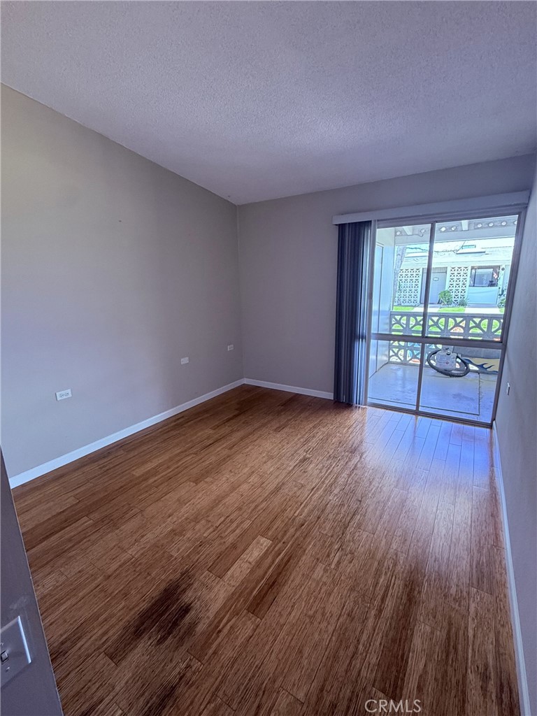 1661 Monterey Road, Unit 16D Seal Beach, CA 90740 - Photo 2 of 9 a view of empty room with wooden floor and fan