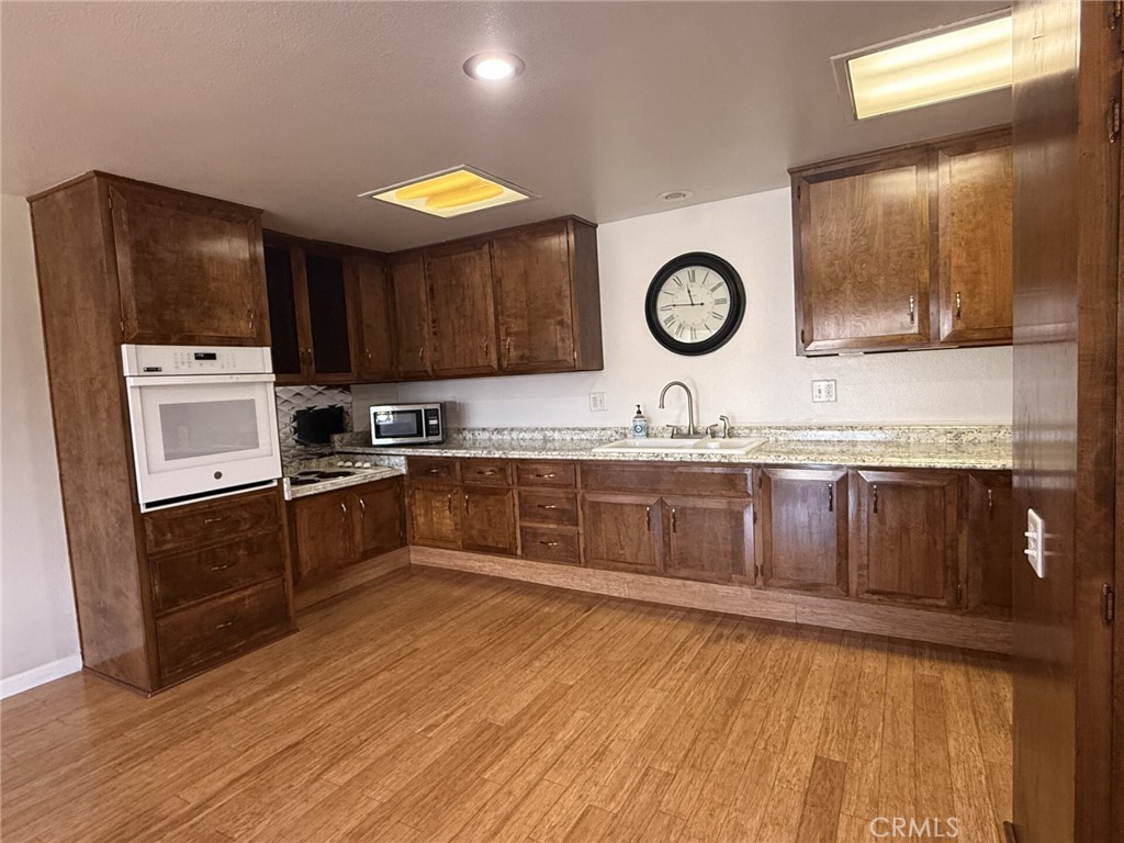 1661 Monterey Road, Unit 16D Seal Beach, CA 90740 - Photo 5 of 9 a kitchen with stainless steel appliances granite countertop a stove a sink and a microwave