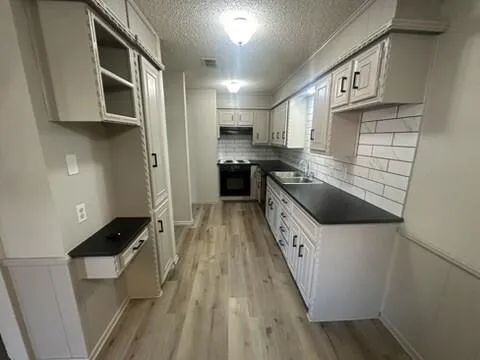 a kitchen with stainless steel appliances a stove a microwave a sink and cabinets