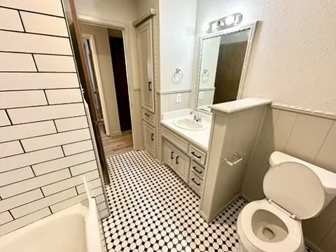 a bathroom with a sink a toilet a mirror and shower