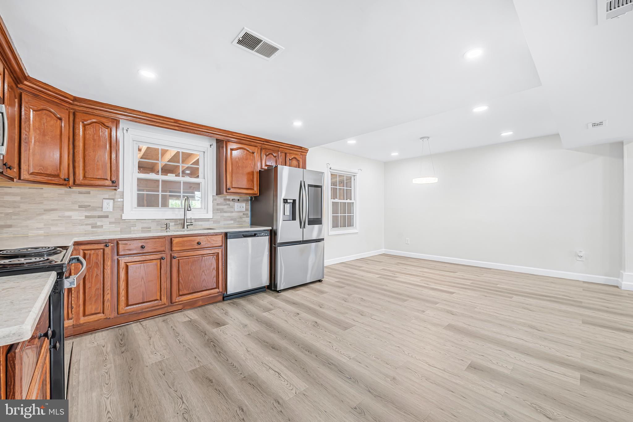 7958 Citadel Drive Severn, MD 21144 - Photo 13 of 32 a large kitchen with stainless steel appliances granite countertop a large counter top and wooden floors