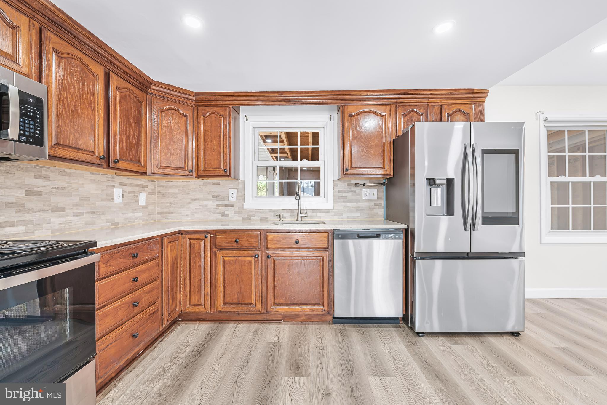 7958 Citadel Drive Severn, MD 21144 - Photo 15 of 32 a kitchen with stainless steel appliances granite countertop a refrigerator oven a sink dishwasher and wooden cabinets with wooden floor